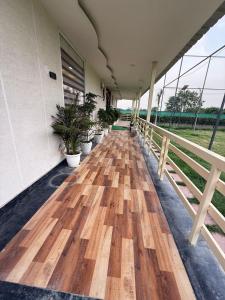 a hallway with a wooden floor and potted plants at Oliv Faram house in Greater Noida