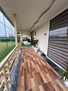 a balcony with a wooden floor and a fence at Oliv Faram house in Greater Noida