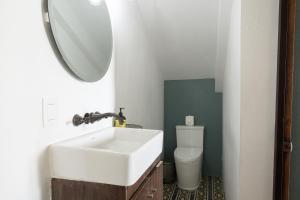 ein Badezimmer mit einem weißen Waschbecken und einer Toilette in der Unterkunft Hotel Villa 1927 in Chapala + 25 Fotos