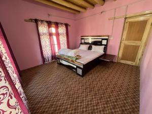 a bedroom with a bed in a pink room at Tsetanpa homestay in Leh
