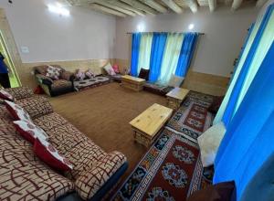 a living room with couches and a table at Tsetanpa homestay in Leh
