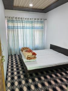 a bed in a room with a window at Tsetanpa homestay in Leh