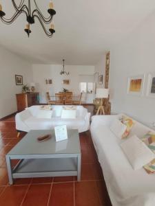 a living room with two white beds and a table at Chalet Matalascañas in Matalascañas