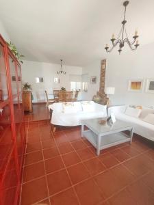 a living room with two white couches and a table at Chalet Matalascañas in Matalascañas