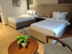 a hotel room with two beds and a table with a plant at Hotel Luxe Manor in Mohali +256 photos