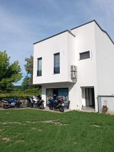 a group of motorcycles parked in front of a white house at Apartman Una na dlanu, Novi Grad in Bosanski Novi