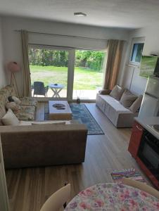 a living room with a couch and a table at Apartman Una na dlanu, Novi Grad in Bosanski Novi