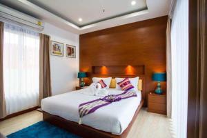 a bedroom with a large bed with a wooden headboard at The Sun Pool Villa in Chaweng +43 photos