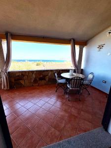 a dining room with a table and chairs and a large window at Villa Relax in Santa Lucia +33 photos