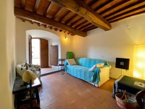 a living room with a blue couch and a tv at Fortress overlooking the sea in Porto Ercole