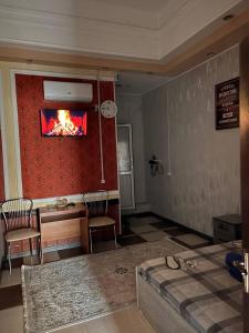 a living room with a fire painting on the wall at Отель "VOSTOK" in Yalanghoch