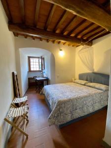 a bedroom with a bed and a desk and a window at Fortress overlooking the sea in Porto Ercole