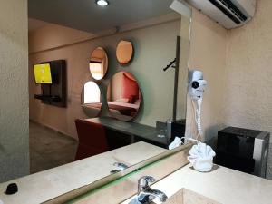 a mirror in a bathroom with a sink and a bed at Hotel Yahalis in Jilotepec de Abasolo +32 photos