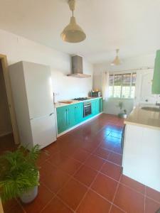 a kitchen with blue cabinets and a red tile floor at Chalet Matalascañas in Matalascañas +31 photos