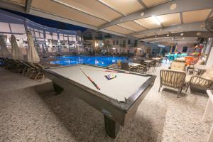 a pool table in front of a swimming pool at Belcehan Hotel in Oludeniz