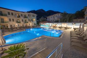 a swimming pool in front of a hotel at night at Belcehan Hotel in Oludeniz