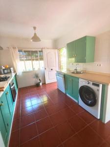 a kitchen with green cabinets and a washing machine at Chalet Matalascañas in Matalascañas