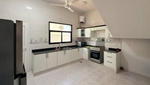 a large kitchen with white cabinets and a window at Villa Berka in Barka