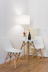 ローマにあるSuite Cardinaleの白い椅子2脚、テーブル(ランプ付)
