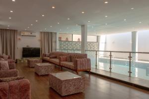 a living room with couches and a television and a pool at Villa Berka in Barka