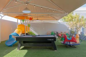 a ping pong table in a play area with a pool at Villa Berka in Barka