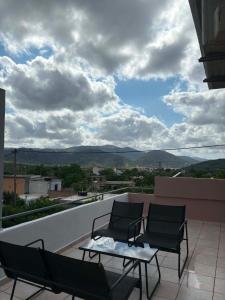 a patio with two chairs and a table on a balcony at Popi's Apartment in Goníai +31 photos