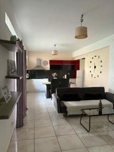 a living room with a couch and a kitchen at Popi's Apartment in Goníai