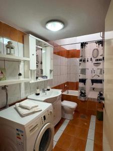 a bathroom with a washing machine and a sink at Popi's Apartment in Goníai