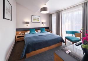 a hotel room with a bed and a desk and chair at Hotel Visegrád in Visegrád