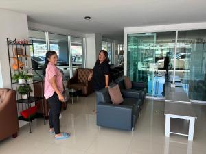 two women are standing in a living room at Beach Front Condo Centerviews Bangsaray Floor 6 in Bang Sare +49 photos