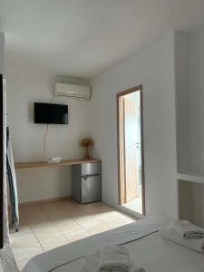 a bedroom with a bed and a desk with a television at Popi's Apartment in Goníai