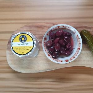 a bowl of grapes and a pickle on a cutting board at The Guest Room, Barossa in Nuriootpa