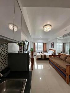 a kitchen and living room with a couch and a bed at Sea Residences Sunset Point in Manila