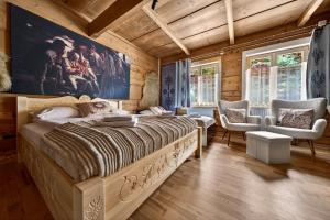 a bedroom with a large bed and two chairs at Domek u Świerków 2 - Zabytkowe domki 4 do 8 osób i apartamenty z aneksem kuchennym, 1,5km Termy Chochołowskie in Chochołów +76 photos
