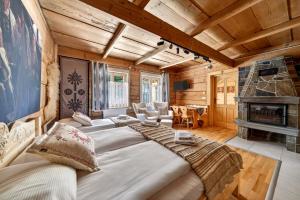 a large bed in a room with a fireplace at Domek u Świerków 2 - Zabytkowe domki 4 do 8 osób i apartamenty z aneksem kuchennym, 1,5km Termy Chochołowskie in Chochołów