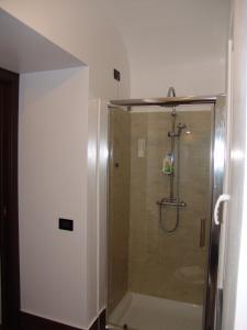 La salle de bains est pourvue d'une douche avec une porte en verre. dans l'établissement InCentro Apartments, à Milazzo