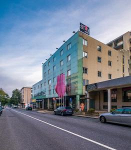 um edifício numa rua com carros estacionados em frente em Stay Hotel Guimarães Centro em Guimarães