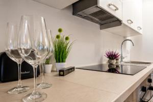three wine glasses sitting on a counter in a kitchen at Valora Central Apartment in Vrhnika