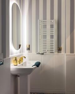 a white bathroom with a sink and a mirror at Apartament z Jacuzzi Kraków ART Koletek in Krakow +23 photos
