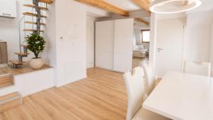 a kitchen and living room with white walls and wood floors at Valora Central Apartment in Vrhnika