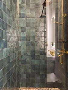 a bathroom with a shower with green tiles at Apartament z Jacuzzi Kraków ART Koletek in Krakow