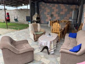 a patio with two couches and a table and chairs at Дом с бассейном в Ереване in Davitashen