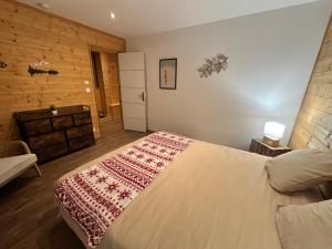 a bedroom with a bed with a red blanket on it at L'Appart'Chalet du Revermont in Cousance