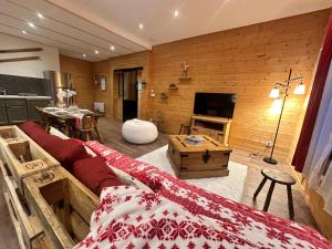 a living room with a couch and a television at L'Appart'Chalet du Revermont in Cousance