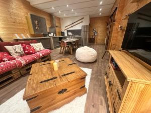 a living room with a couch and a table at L'Appart'Chalet du Revermont in Cousance