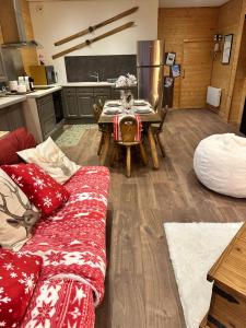 a kitchen with a couch and a table in a room at L'Appart'Chalet du Revermont in Cousance +12 photos