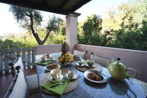a table with plates of food and a teapot at Casa Rosa di Cavoli in Seccheto