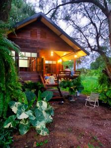 a group of people sitting in the porch of a log cabin at Tamarind nest in Sai Yok