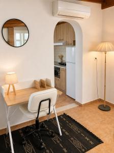 a kitchen with a desk and a white refrigerator at The simple two-bedroom house at Klima Beach in Samos +5 photos
