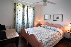 a bedroom with a bed and two windows with curtains at Casa Rosa di Cavoli in Seccheto